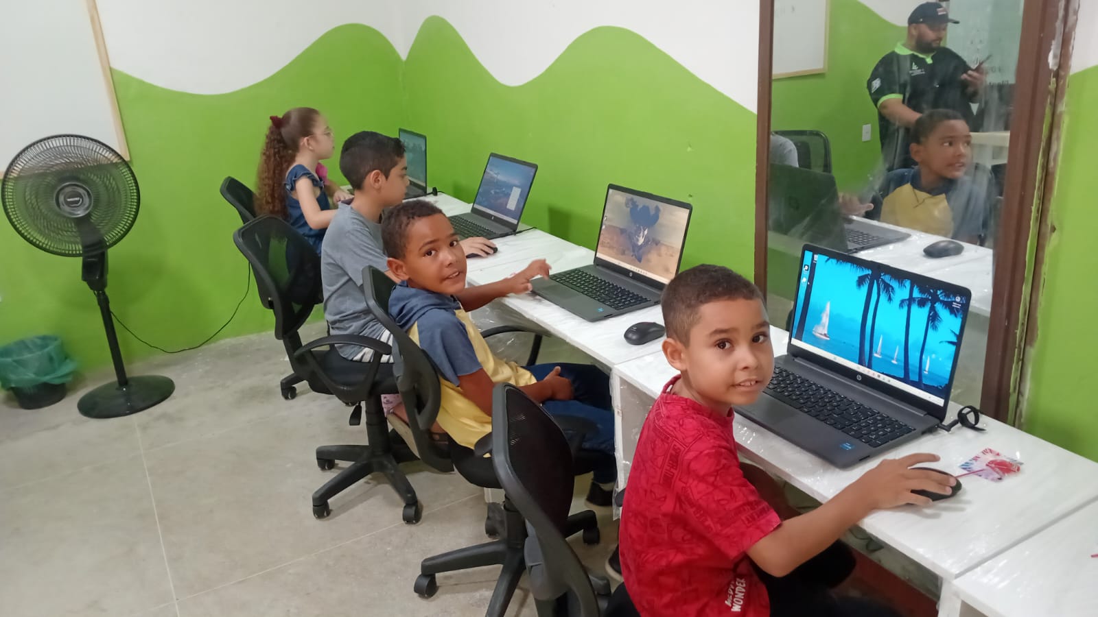 Crianças utilizando computadores na sala do projeto