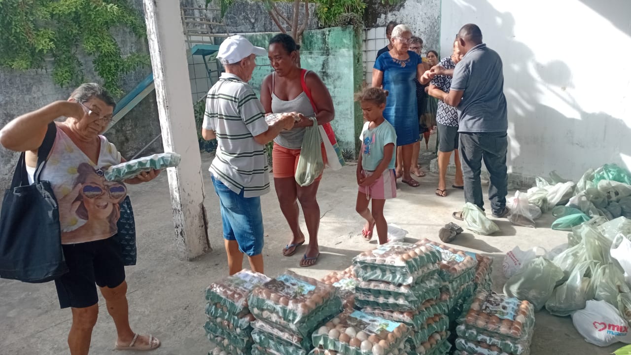 Participantes recebem alimentos em um espaço comunitário