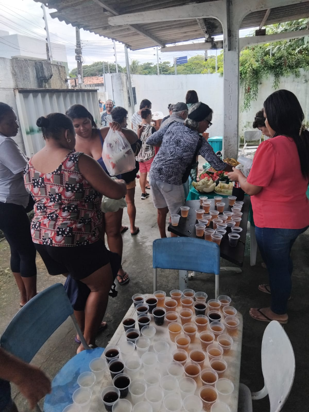 Participantes com sacolas de alimentos em um encontro comunitário