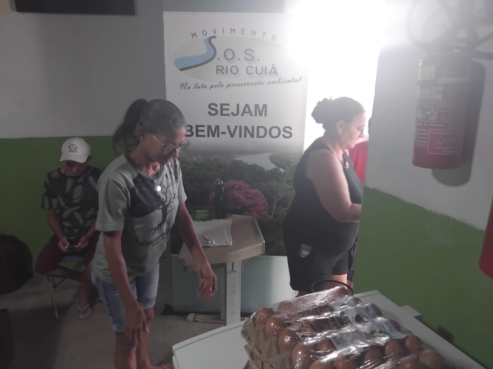 Pessoas em espaço com a marca do Movimento SOS Rio Cuiá e bandejas de ovos